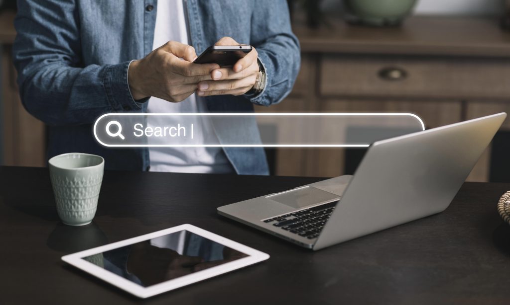 He looks at his phone and searches on Google